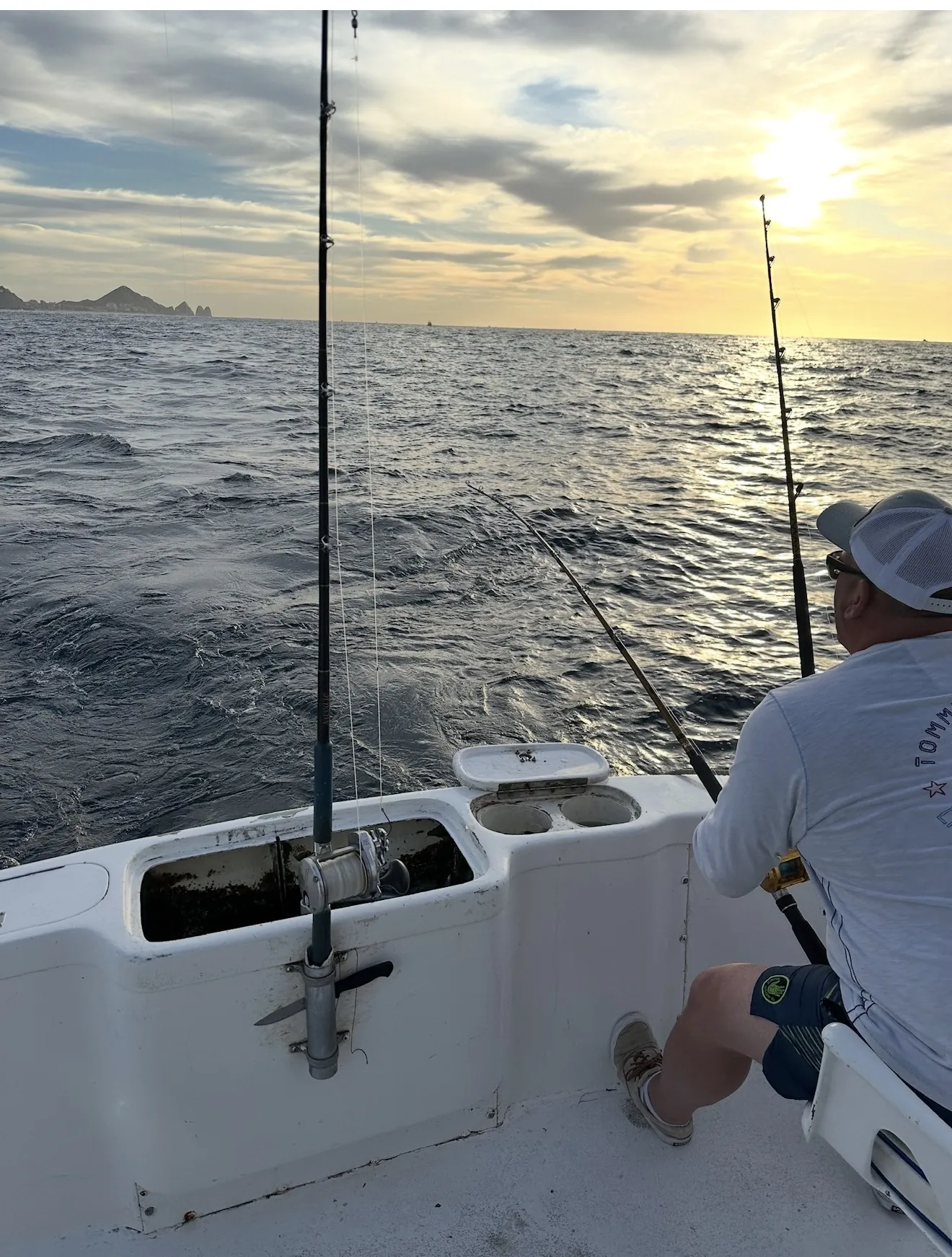 Guest fishing from the stern as the sun rises off Land's End in Cabo San Lucas