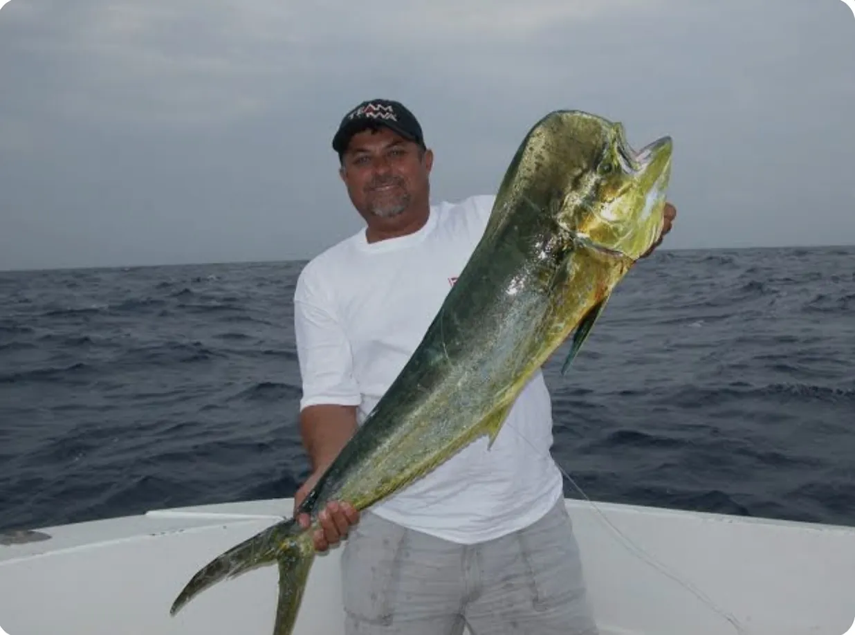 Guest holding a trophy dorado aboard Elite Sport Fishing